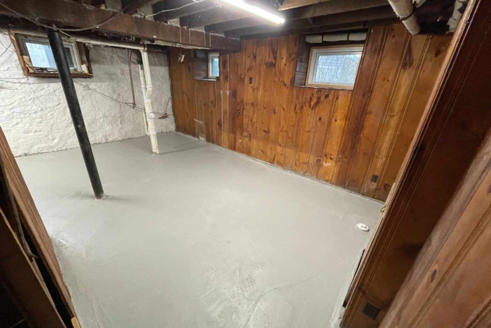 completed basement masonry project with gray floor and wood walls